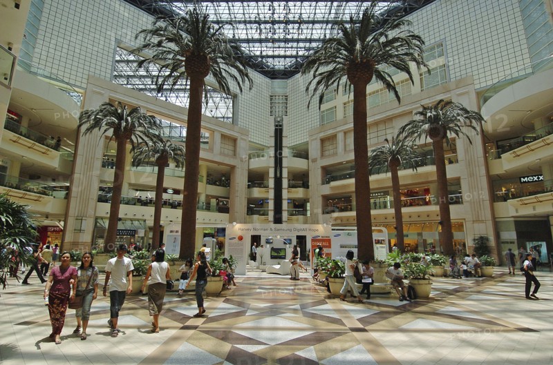 SINGAPORE, Raffles City, Interior of a shopping centre with palm trees.