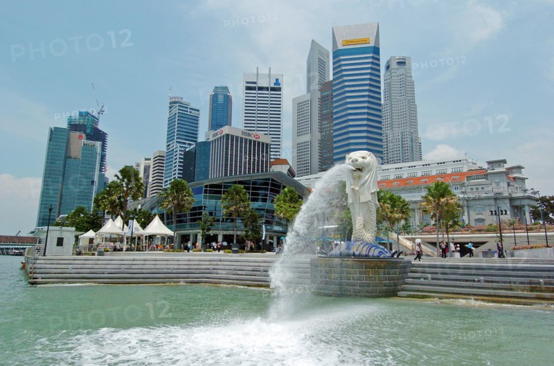 SINGAPORE, Financial District, "MERLION STATUE SITUATED INFRONT OF THE FULLERTON HOTEL AND FINACIAL DISTRICT BEHIND. The Merlion is one of the most well-known tourist icons of Singapore. Its landmark statue, once at the Merlion Park, was relocated to the front of the Fullerton Hotel in April 2002.In 2002, the statue was relocated to its current site that fronts Marina Bay with the completion of the Esplanade Bridge in 1997. The statue measures 8.6 metres high and weighs 70 tonnes. The merlion was designed by Fraser Brunner for the Singapore Tourism Board in 1964 and was used as its logo up to 1997. The Merlion continues to be its trademark symbol."