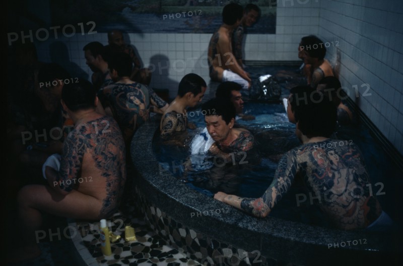 Heavily tattooed gangster or Yakuza gang members in public bath house