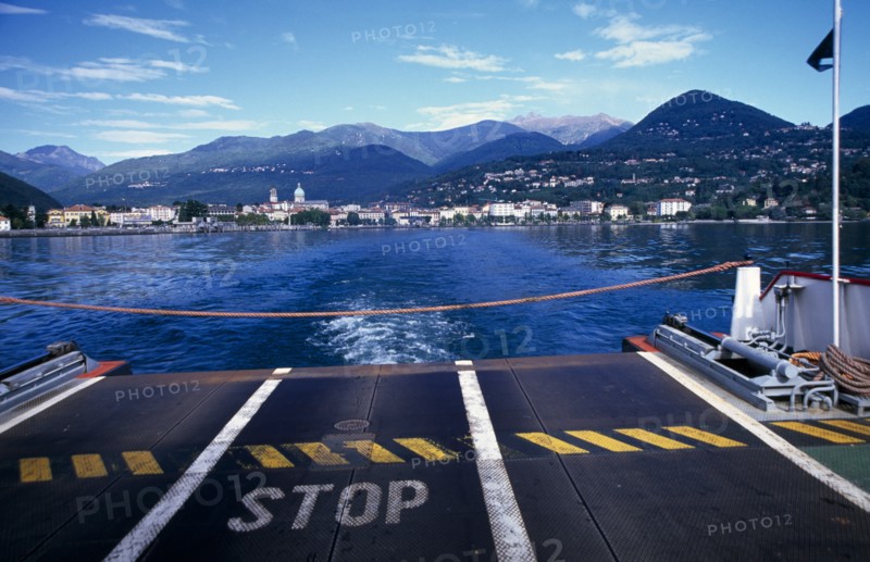 ITALY, Piedmont, Pallanza, View across Lake Maggiore towards shoreline and Pallanza from the ferry with warning Stop sign on ferry deck in foreground and rope across end.