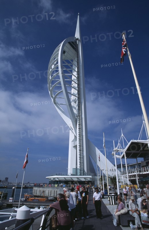 ENGLAND, Hampshire, Portsmouth, Gunwharf Keys. The Spinnaker Tower with people on the waterfront promenade looking out across the marina