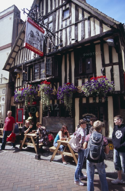 ENGLAND, East Sussex, Hastings, Old Town. George Street . Tmbered frontage of Ye Olde Pump House pub with people sitting outside at tables under hanging baskets
