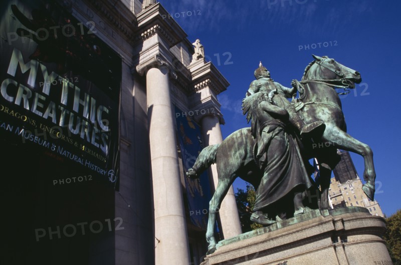 USA, New York, New York City, "American Museum of Natural History, Central Park West entrance with bronze statue of President Theodore Roosevelt on horseback and exhibition posters."