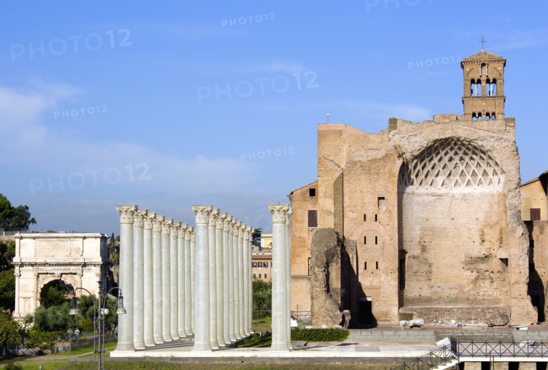 ITALY, Lazio, Rome, "The Forum The Temple of Venus and Roma (Latin: Templum Veneris et Romae) with fibregalss reconstructions of its Corinthian columns in the foreground. It was the largest known temple in Ancient Rome. Located at the far east side of the Forum Romanum near the Colosseum, it was dedicated to the goddesses Venus Felix (Venus the Bringer of Good Fortune) and Roma Aeterna (Eternal Rome). The architect was the emperor Hadrian. Construction of the temple began in 121. It was officially inaugurated by Hadrian in 135, and finished in 141 under Antoninus Pius. Damaged by fire in 307, it was restored with alterations by the emperor Maxentius. On the left is the Arch of Titus"