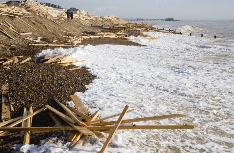 ENGLAND, West Sussex, Worthing, Timber washed up on the beach from the Greek registered Ice Princess which sank off the Dorset coast on 15th January 2008. People walking past waves crashing against the shoreline