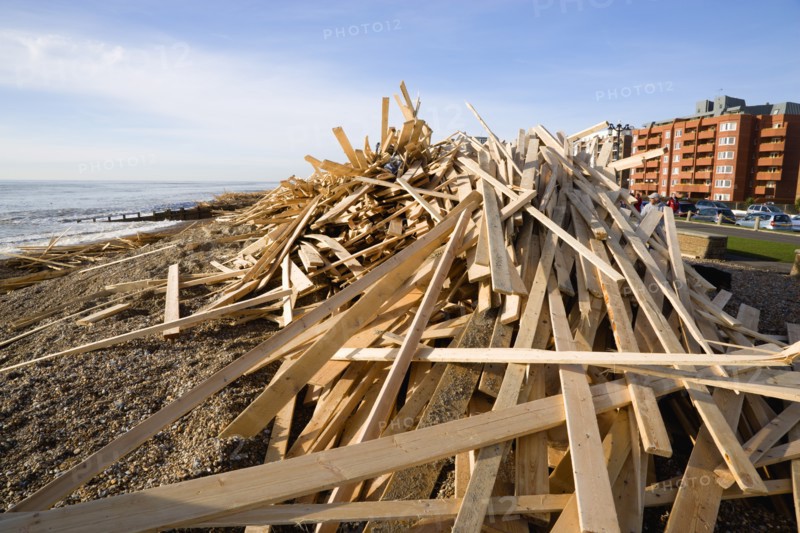 ENGLAND, West Sussex, Worthing, Timber washed up on the beach from the Greek registered Ice Princess which sank off the Dorset coast on 15th January 2008. People walk on the promenade with seafront buildings beyond