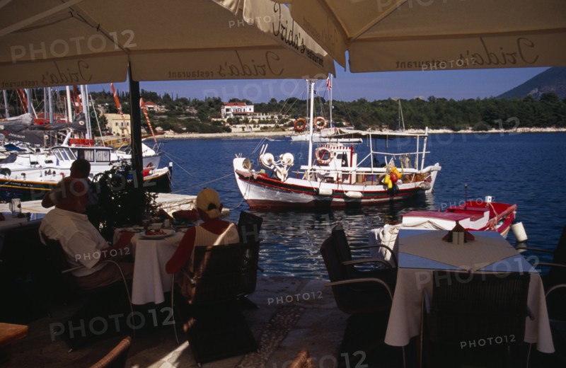 GREECE, Ionian Islands, Cephalonia, Waterside cafe in Fiskardo harbour.