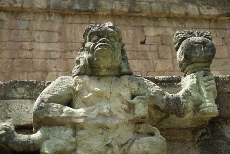 HONDURAS, Copan, Site of ancient Mayan ruins.  Detail of statue of figure holding burning torch.