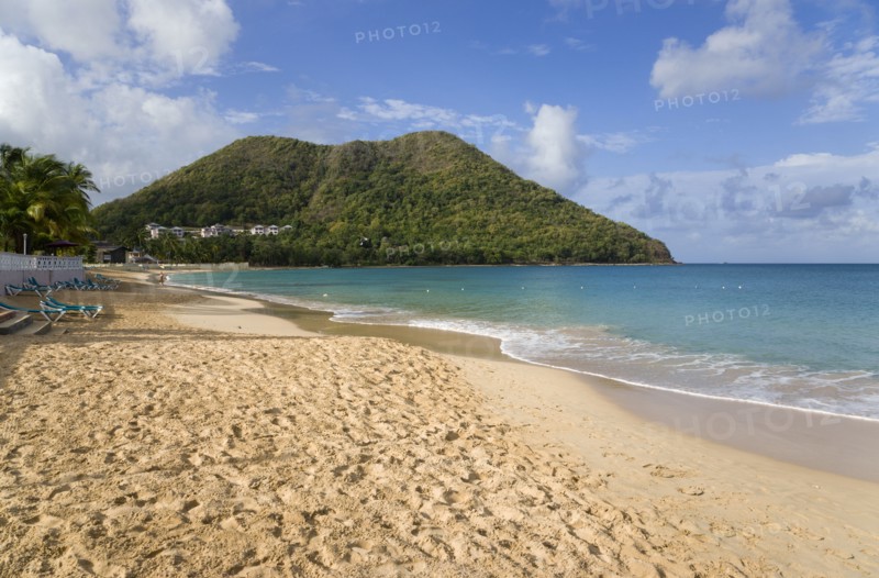 WEST INDIES, St Lucia, Gros Islet, Reduit Beach in Rodney Bay during the early morning with tourists walking by the waterline