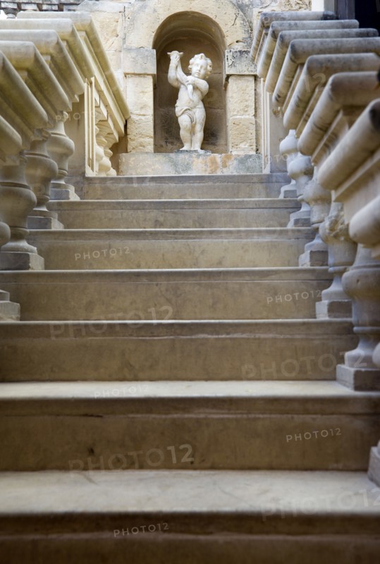 MALTA, Mdina, The Silent City. Statue of a cherub at the top of stone steps in the Fontanella Tearooms garden