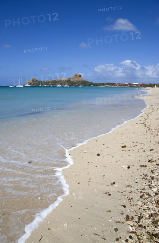 WEST INDIES, St Lucia, Gros Islet , Pigeon Island National Historic Park seen from a nearby beach on a causeway to the island with yachts at anchor in Rodney Bay