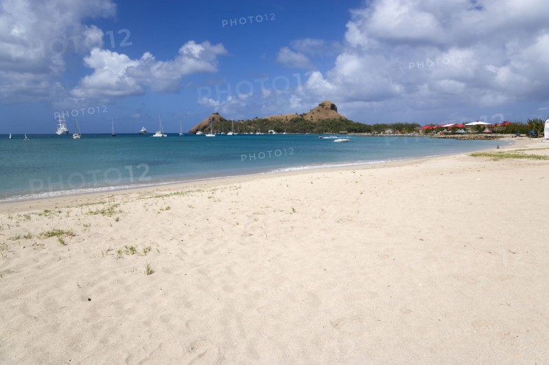 WEST INDIES, St Lucia, Gros Islet , Pigeon Island National Historic Park seen from a nearby beach on a causeway to the island with yachts at anchor in Rodney Bay