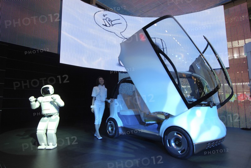 JAPAN, Honshu, Chiba, "2007 Tokyo Car Show, Honda exhibit, Asimo Robot presents Honda concept car Puyo, young woman opens car's gull-wing doors"