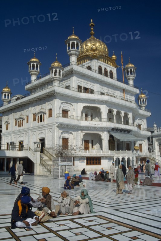 INDIA, Punjab, Amritsar, The Sri Akal Takhat Sahib Sikh Parliment building in the Golden Temple with groups of people gathered outside