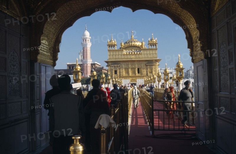 INDIA, Punjab, Amritsar, Entrance arch to the Golden Temple with people walking along red carpet