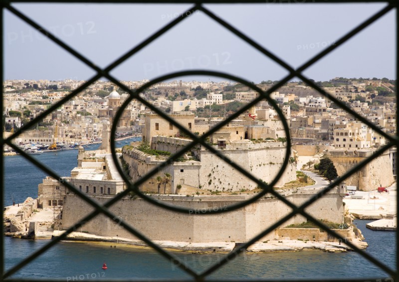 MALTA, Valletta, Fort Saint Angelo on Vittoriosa one of the Three Cities in Valletta Harbour seen through the metal railings of the Upper Barrakka Gardens in Valletta