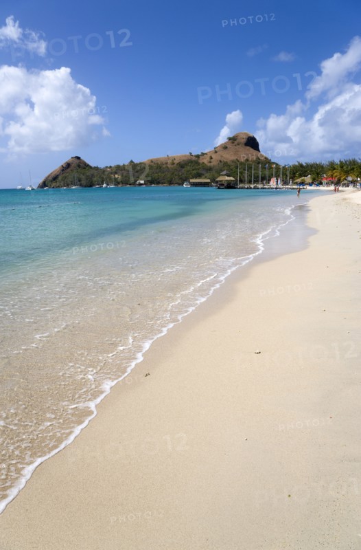 WEST INDIES, St Lucia, Gros Islet , The beach at Sandals Grande St Lucian Spa and Beach Resort hotel with Pigeon Island National Historic Park beyond