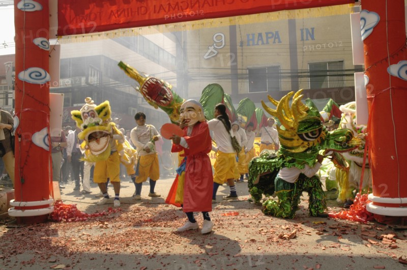 THAILAND, North, Chiang Mai, "Chinese New Year celebrations. Dwarf, lion dancers, dragon dancers and exploding firecrackers at the conclusion of the parade, Warorot Market area Chiang Mai's China Town, "