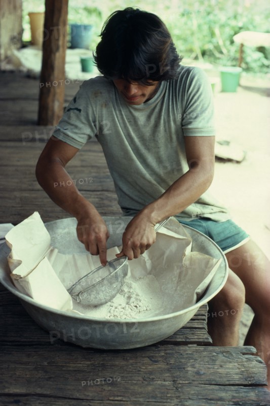 COLOMBIA, Vaupes, William  half-Tukano Indian whose father runs this illegal cocaine lab.  Sieves base cocaine before processing to final product