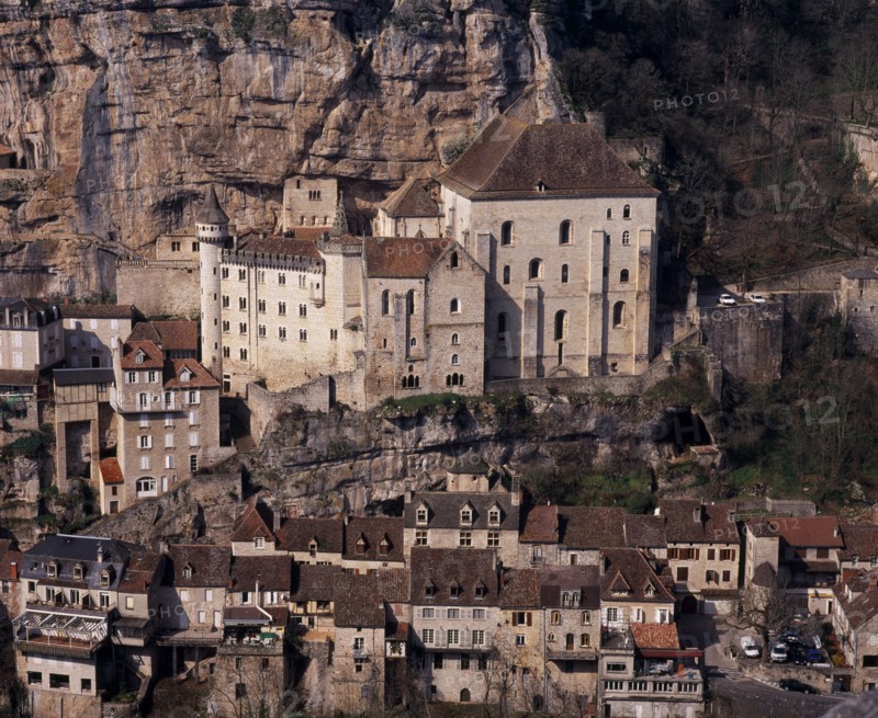 FRANCE, Midi-Pyrenees, Lot, Rocamadour.  Twelth century Basilica of St-Sauveur centre right and Museum of Sacred Art situated at base of cliff above cluster of old village buildings.