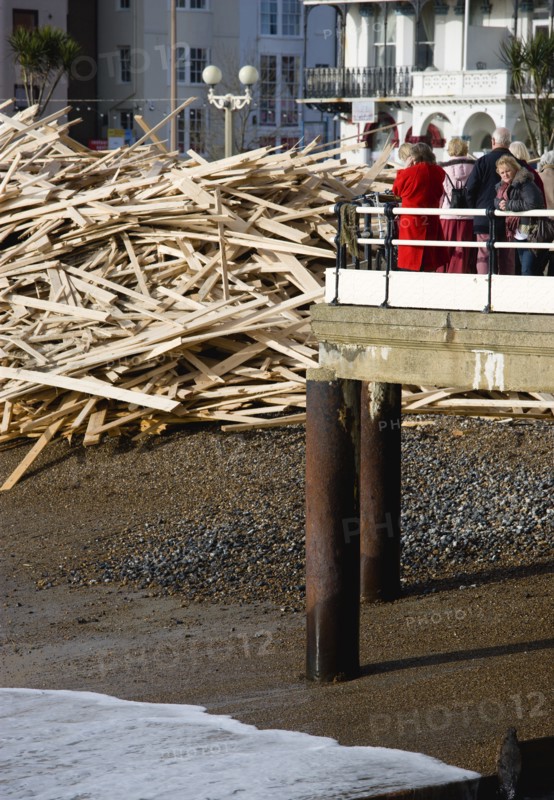 ENGLAND, West Sussex, Worthing, Timber washed up on the beach from the Greek registered Ice Princess which sank off the Dorset coast on 15th January 2008. Sightseers on the pier look at the debris beside it
