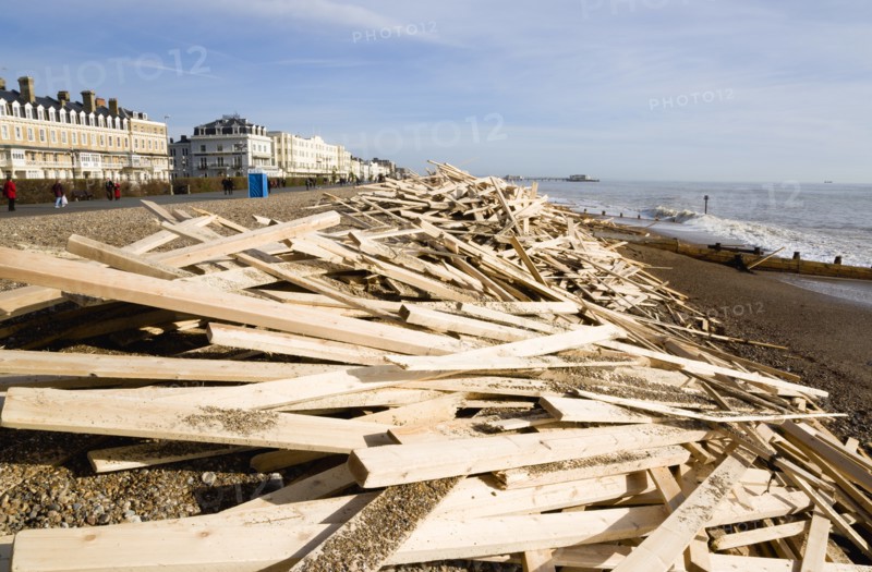 ENGLAND, West Sussex, Worthing, Timber washed up on the beach from the Greek registered Ice Princess which sank off the Dorset coast on 15th January 2008. People walk past on the promenade past seafront buildings with Worthing Pier in the ditance