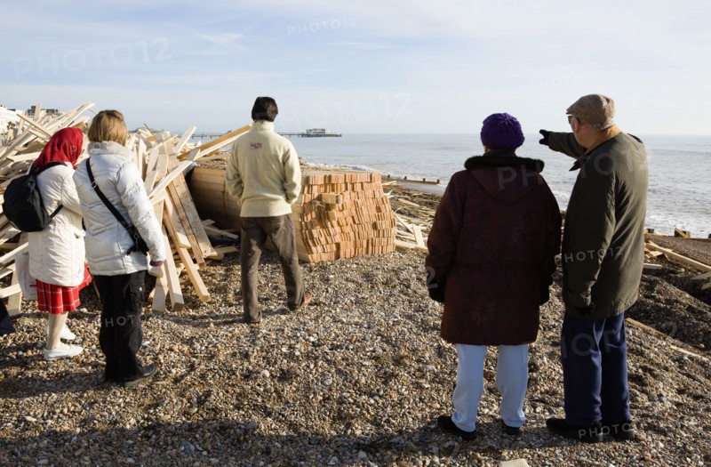 ENGLAND, West Sussex, Worthing, Timber washed up on the beach from the Greek registered Ice Princess which sank off the Dorset coast on 15th January 2008. Five people stand amongst the debris with Worthing Pier in the distance
