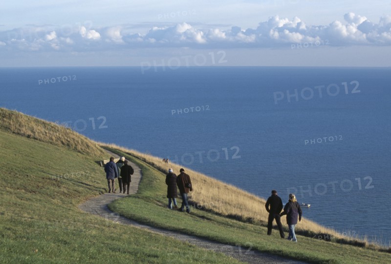 ENGLAND, East Sussex, Eastbourne, People walking together along winding path on cliff walk by Beachy Head