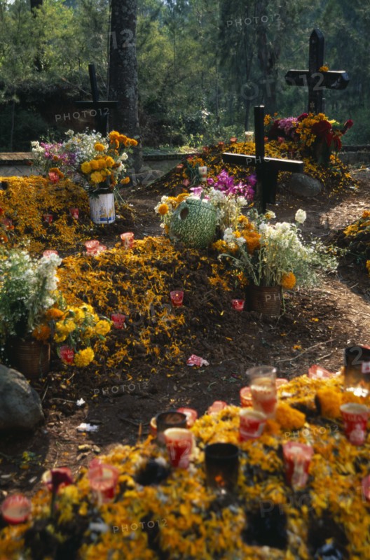 MEXICO, Michoacan, Patzcuaro, "Tzurumutaro Cemetery.  Graves decorated with candles, carved pumpkins and marigold flowers for the Day of the Dead."