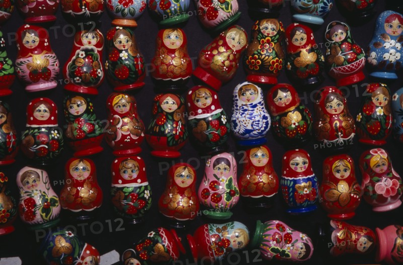 HUNGARY, Budapest, Colourful painted matryoshka dolls for sale in souvenir shop.  Displayed in lines against dark backgound.