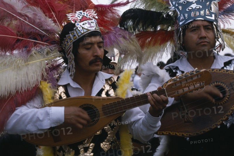 MEXICO, Mexico City, Musicians wearing elaborate feather head-dresses and costumes during Festival of Our Lady of Guadaloupe