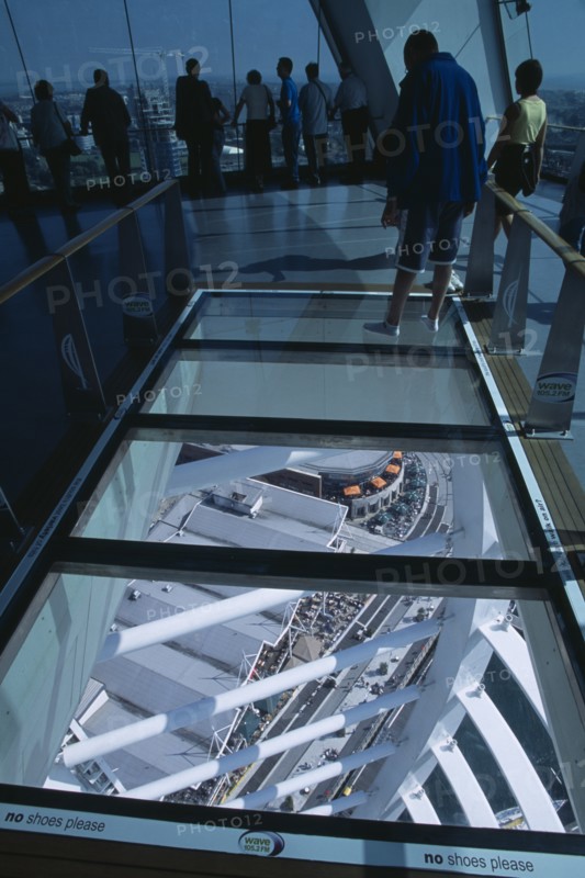 ENGLAND, Hampshire, Portsmouth, "Gunwharf Quays. The Spinnaker Tower. Interior at top of tower with a glass floor window  looking down.Visitors looking out glass windows on the observation deck providing a 320° view of the city of Portsmouth, the Langstone and Portsmouth harbours."