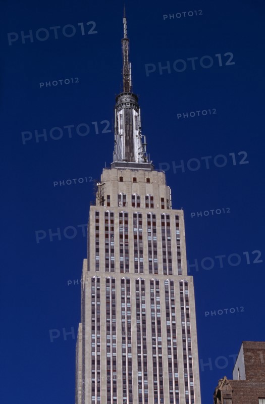 USA, New York, New York City, "Part view of the Empire State Building from East 34th Street.  Art Deco, steel framed building with radio and TV mast completed in 1931.   Designed by architect William Lamb of Shreve, Lamb and Harmon Associates."
