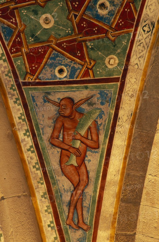 ITALY, Lombardy, Lake Maggiore, Angera.  Architectural detail and painting in Rocca di Angera medieval castle depicting figure carrying fish and abstract pattern set in space between arches or spandrel