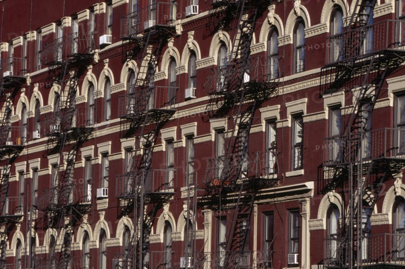 USA, New York, New York City, "Greenwich Village.  Houses on 7th Avenue, red brick exteriors with cream coloured architectural detail and decorative metal fire escapes."
