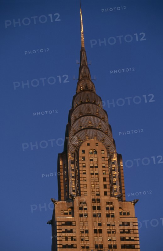 USA, New York, New York City, Part view of the Chrysler Building from East 42nd Street lit by golden light.  Steel framed Art Deco skyscraper built 1928-1930 and designed by architect William Van Alen.