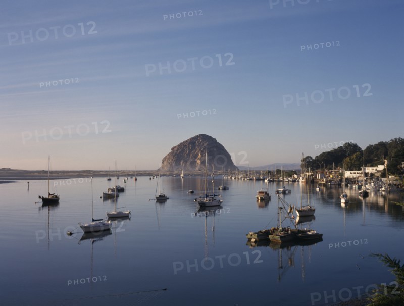 USA, California, Morro Bay, Harbour with moored yachts and Morro Rock seen across water