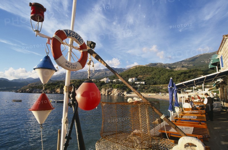 MONTENEGRO, Przno, Waterfront restaurants with fishing nets and nautical decoration looking out towards the sea