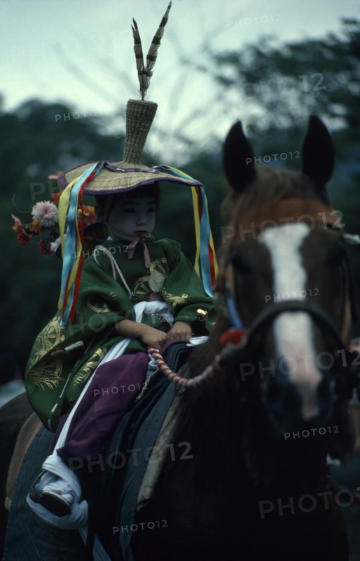 JAPAN, Honshu, Kyoto, Gion Festival.  A young boy dressed as a courtier of the Heian period prepares to ride through the streets of Kyoto.