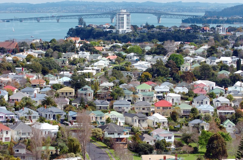 NEW ZEALAND, NORTH ISLAND, AUCKLAND, GENERAL VIEW OF THE RESIDENTIAL DISTRICT OF DEVENPORT IN THE FOREGROUND AND ON TO STANLEY POINT AND AUCKLANDS HARBOUR BRIDGE CARRYING ROUTE 1 MOTORWAY CROSSING WAITEMATA HARBOUR IN THE DISTANCE.