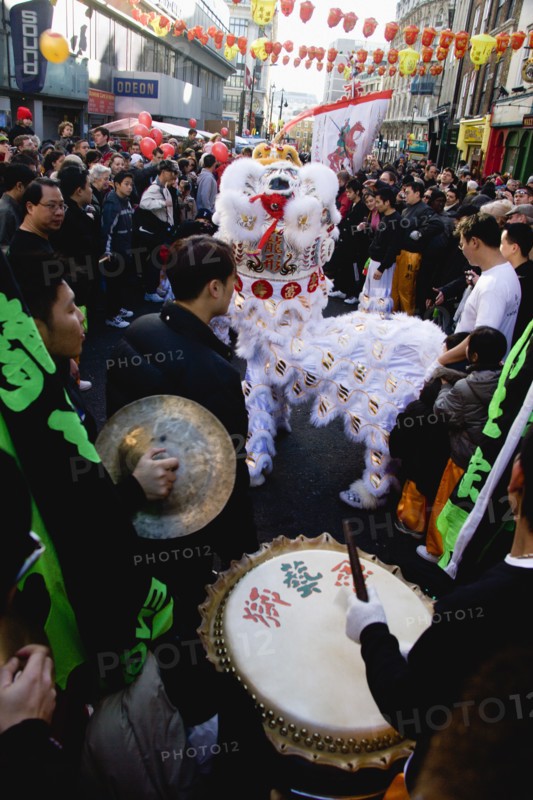 ENGLAND, London, Chinatown, Lion Dance troupe performing in Wardour Street amongst the crowd outside restaurants during Chinese New Year celebrations in 2006 for the coming Year of The Dog