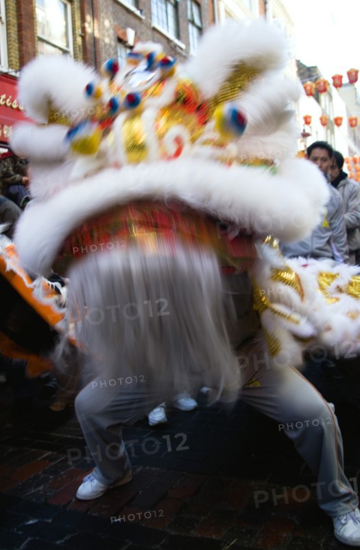ENGLAND, London, Chinatown, Lion Dance troupe performing in Gerrard Street with onlooking crowd during Chinese New Year celebrations in 2006 for the coming Year of The Dog