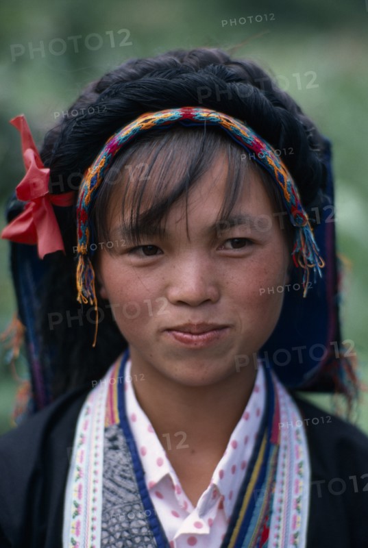 CHINA, Guizhou Province, People, Head and shoulders portrait of Bouyei girl in traditional dress.