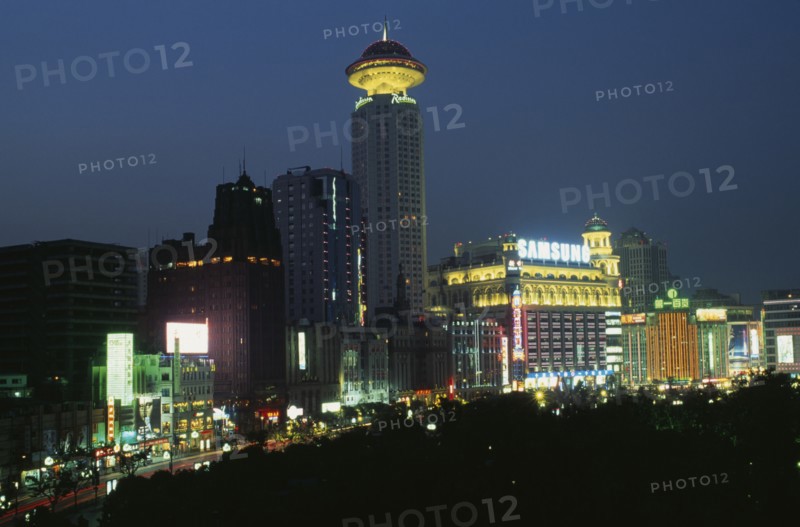 CHINA, Shanghai, "Renmin Square or the People’s Square at night, with buildings illuminated with coloured lights and neon advertising. "