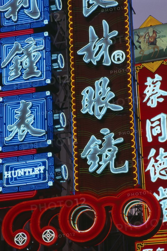 CHINA, Shanghai, Nanjing Lu.  Illuminated neon shop signs in Chinese script.