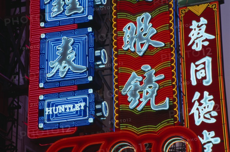 CHINA, Shanghai, Nanjing Lu.  Illuminated neon shop signs in Chinese script.