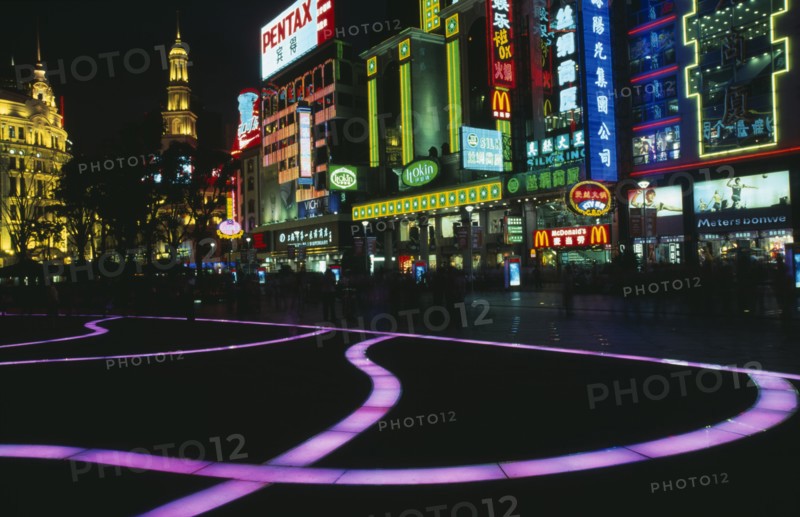 CHINA, Shanghai, "Nanjing Lu.  Street scene at night with illuminated coloured pavement trail, neon shop signs including McDonalds and crowds in blur of movement. "