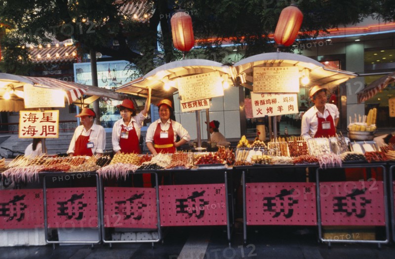 CHINA, Beijing, Food stalls in Donghua Yeshi night market with Chinese lanterns hanging above.
