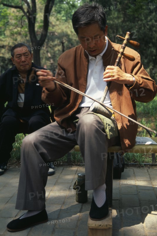 CHINA, Beijing, "Musician in Tian Tian Park playing an Erhu, traditional Chinese violin."