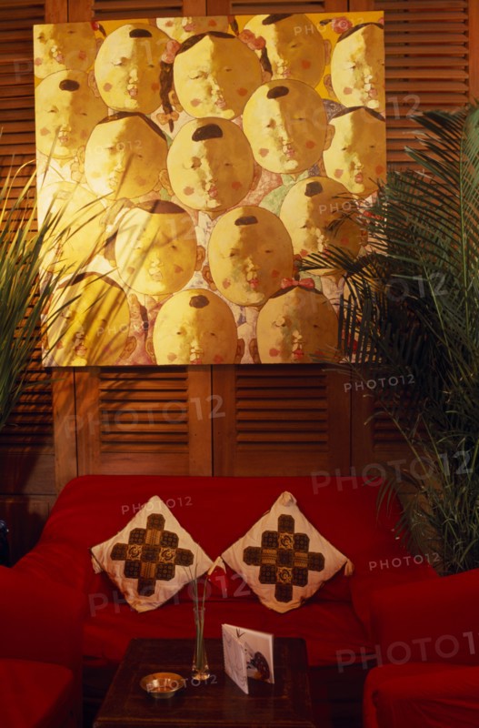 CHINA, Shanghai, "French Concession area.  Seating area in the Face Bar at the Ruijin Guest House.  Red sofa and chairs, potted plants, low wooden table and artwork on wall behind."
